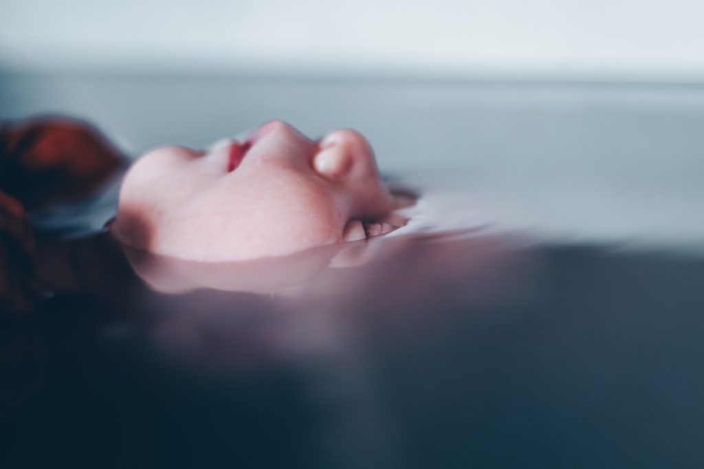 Nouveau-né emmailloté dans l'eau tiède, séance photo bain enveloppé au Teich