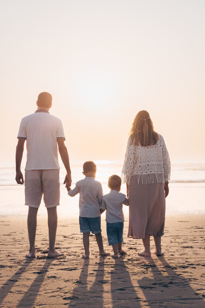Parents et leurs deux enfants au coucher du soleil sur la plage océane de Biscarrosse