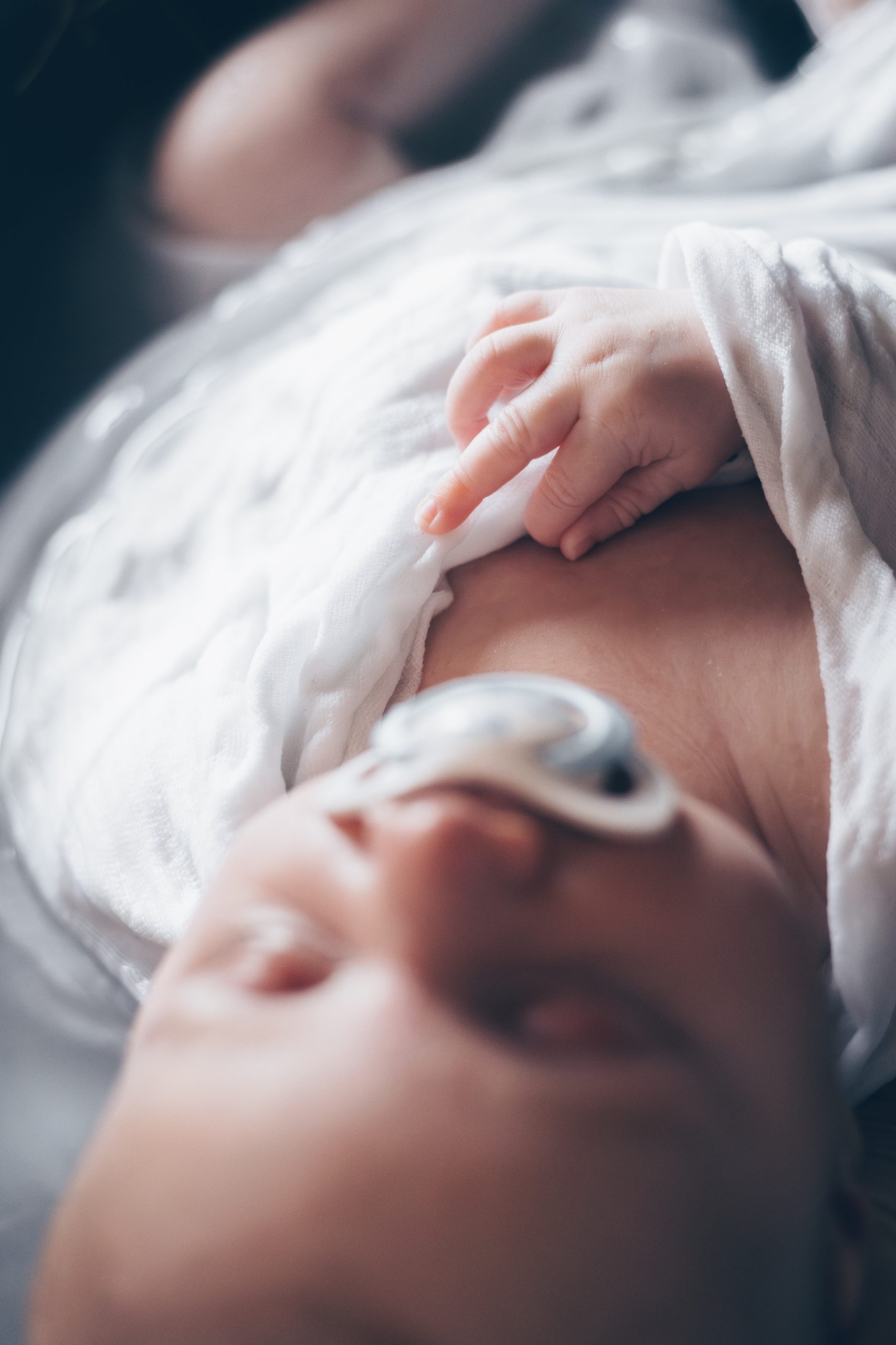 Bébé apaisé dans son bain enveloppé, photographe naissance sur le Bassin d'Arcachon